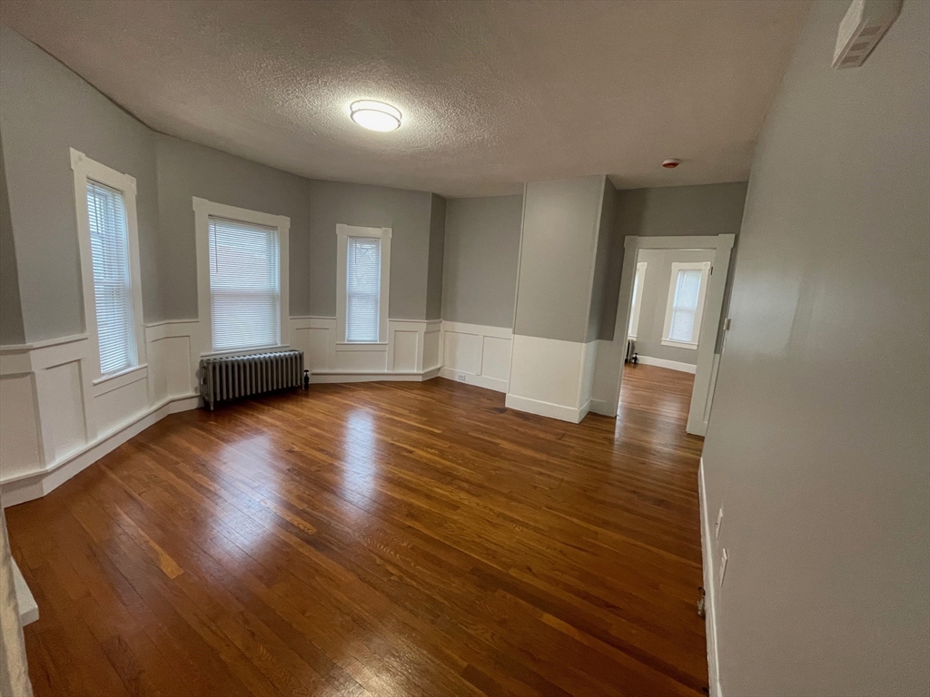 46 Lane Street, Unit 1 Lowell, MA 01851 - Photo 6 of 19 a view of empty room with wooden floor and fan
