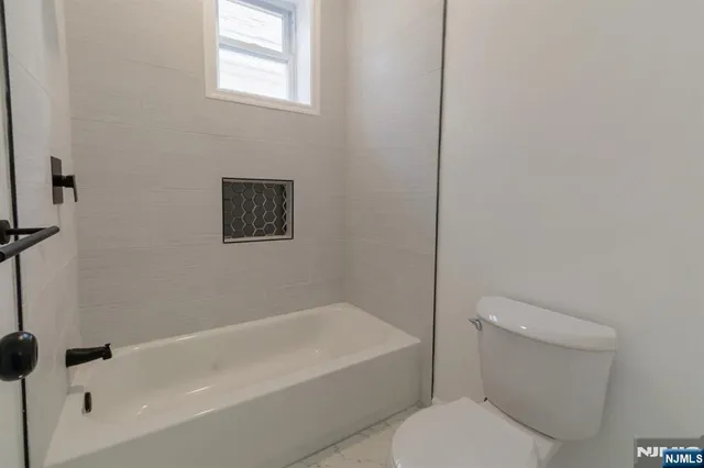 a white toilet sitting next to a bath tub