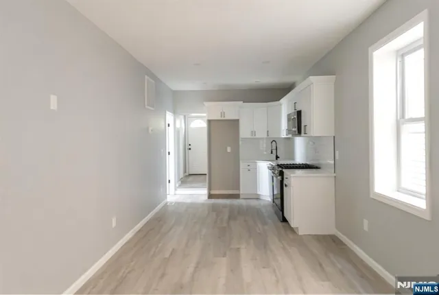 a view of kitchen with refrigerator cabinets and wooden floor