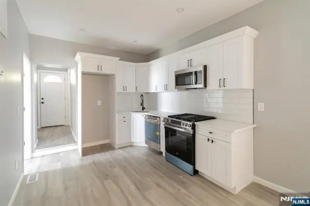 a kitchen with stainless steel appliances granite countertop a refrigerator and a stove top oven