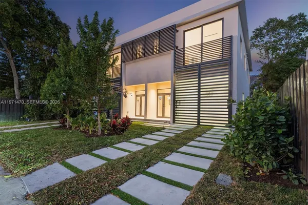a front view of a house with a yard garden and outdoor seating