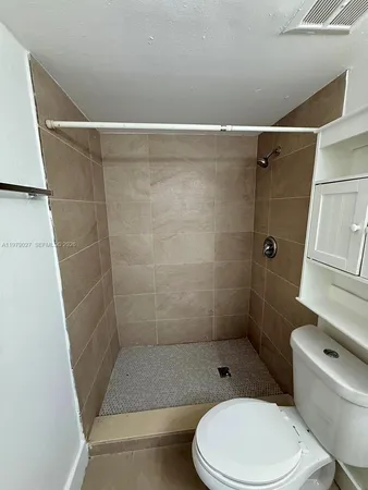 a white toilet sitting next to a bath tub