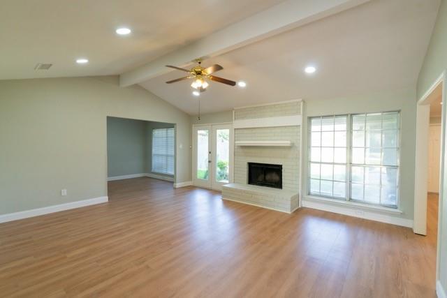 106 Mapleleaf Lane Coppell, TX 75019 - Photo 4 of 36 Spacious living area featuring vaulted ceilings with exposed beams, wood-finish flooring, a painted brick fireplace, and recessed lighting