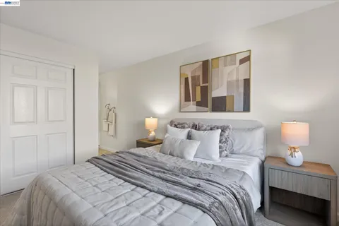 a bedroom with a bed and a lamp on dresser