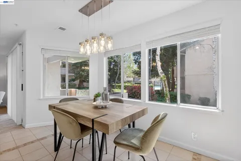 a view of a dining room with furniture large windows and wooden floor
