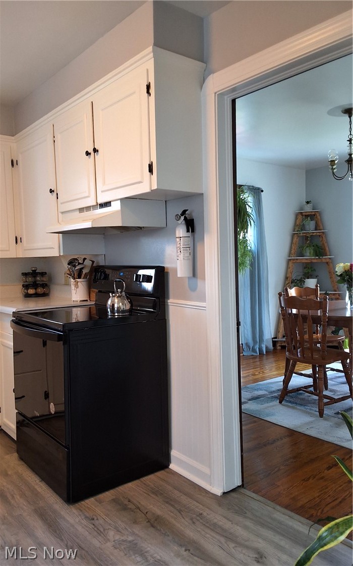236 Bowland Road Mansfield, OH 44907 - Photo 15 of 34 Kitchen featuring white cabinetry with black hardware, white countertops, a black electric range, and wood-finish flooring