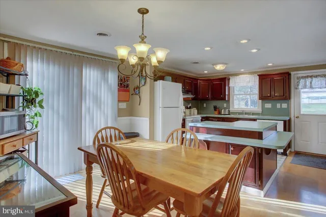 a view of a dining room with furniture a chandelier and wooden floor