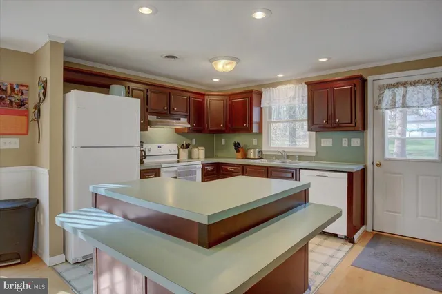 a kitchen with stainless steel appliances granite countertop a refrigerator a sink and a stove