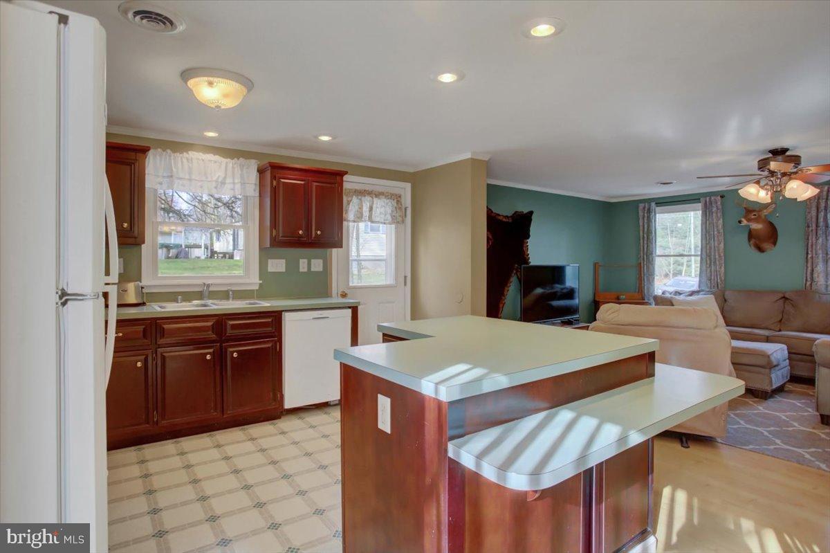 10744 Coral Ridge Road Fayetteville, PA 17222 - Photo 10 of 40 a kitchen with stainless steel appliances granite countertop a sink dishwasher and a refrigerator with wooden floor