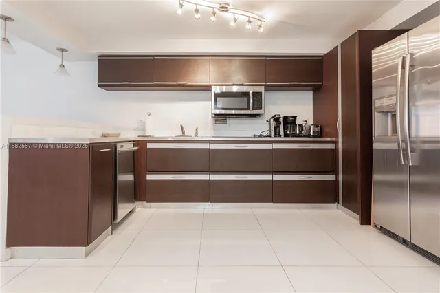 a kitchen with stainless steel appliances granite countertop a refrigerator and a sink