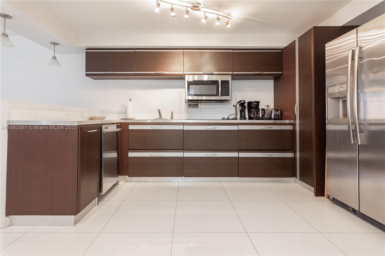 a kitchen with stainless steel appliances granite countertop a refrigerator and a sink