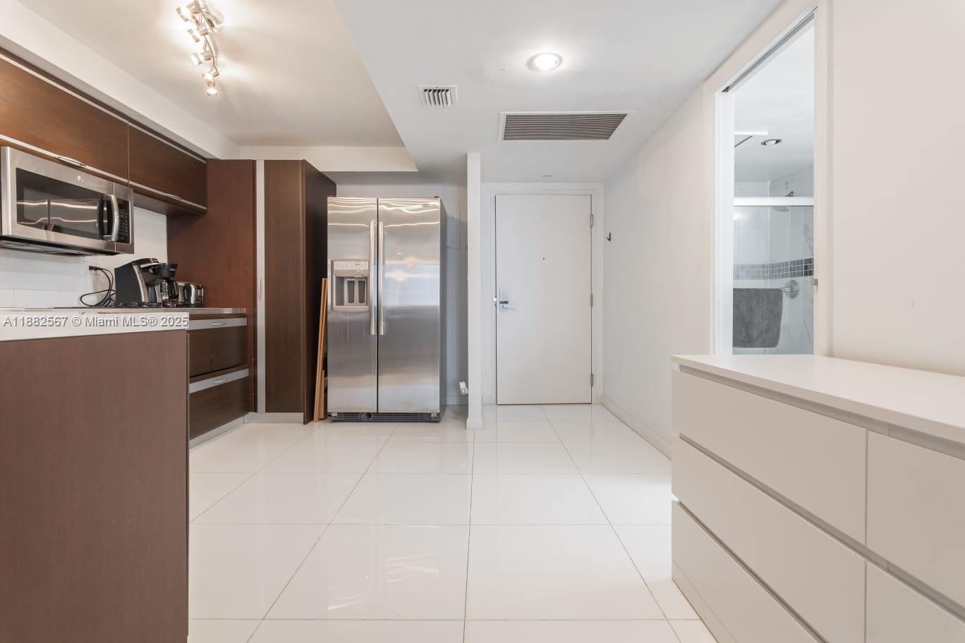 2301 Collins Avenue, Unit 1023 Miami Beach, FL 33139 - Photo 2 of 15 a view of a kitchen with refrigerator and cabinets