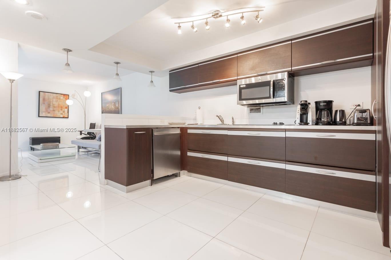 2301 Collins Avenue, Unit 1023 Miami Beach, FL 33139 - Photo 4 of 15 a kitchen with stainless steel appliances granite countertop a sink stove and refrigerator