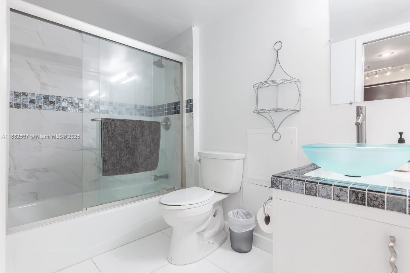 2301 Collins Avenue, Unit 1023 Miami Beach, FL 33139 - Photo 6 of 15 a bathroom with a toilet a sink and shower