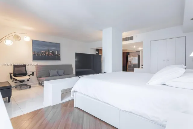 a bedroom with a bed and a flat screen tv