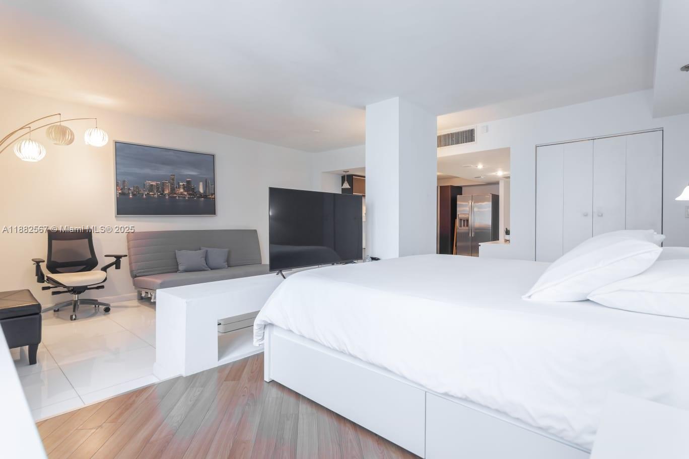 2301 Collins Avenue, Unit 1023 Miami Beach, FL 33139 - Photo 9 of 15 a bedroom with a bed and a flat screen tv