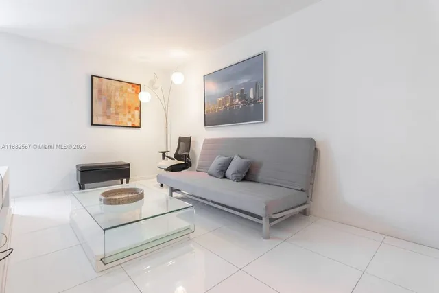 a living room with furniture and a wall painting