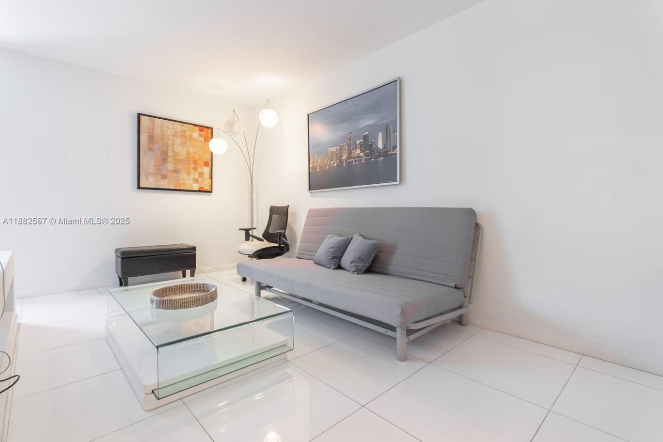 2301 Collins Avenue, Unit 1023 Miami Beach, FL 33139 - Photo 10 of 15 a living room with furniture and a wall painting