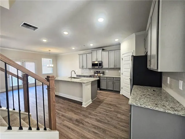 a kitchen with a refrigerator sink and cabinets