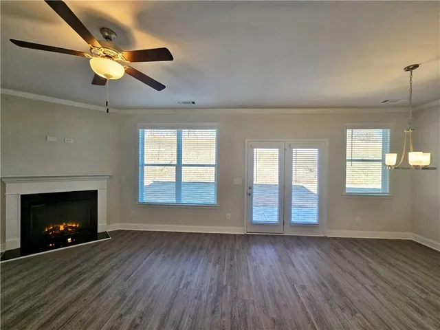 an empty room with windows and fireplace