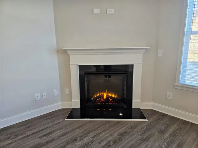 a living room with wooden floor and a fireplace