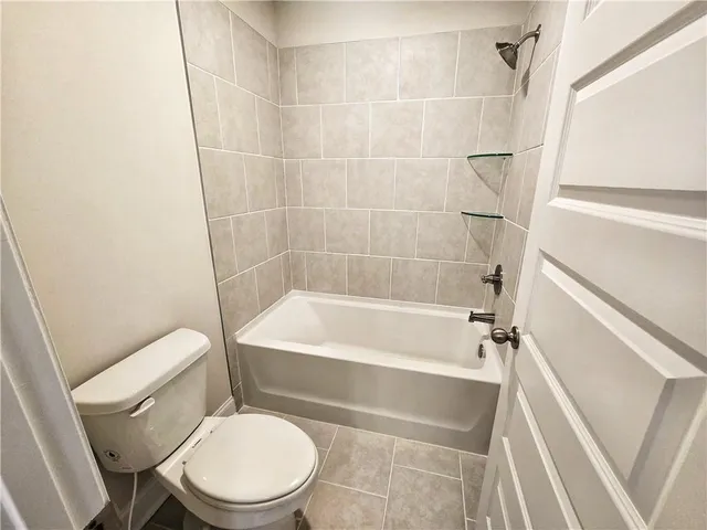 a white toilet and tub sitting next to a white cabinet