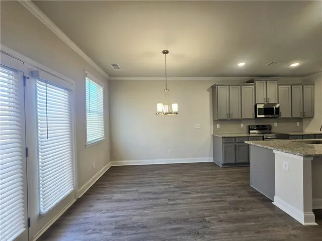 a kitchen with granite countertop a stove a sink and a refrigerator