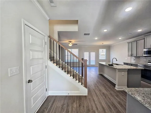 a open kitchen with white cabinets and wooden floor