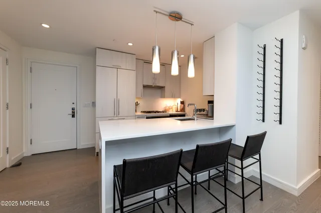 a kitchen with granite countertop white cabinets and stainless steel appliances