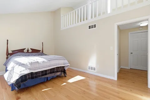 a bedroom with a bed and wooden floor