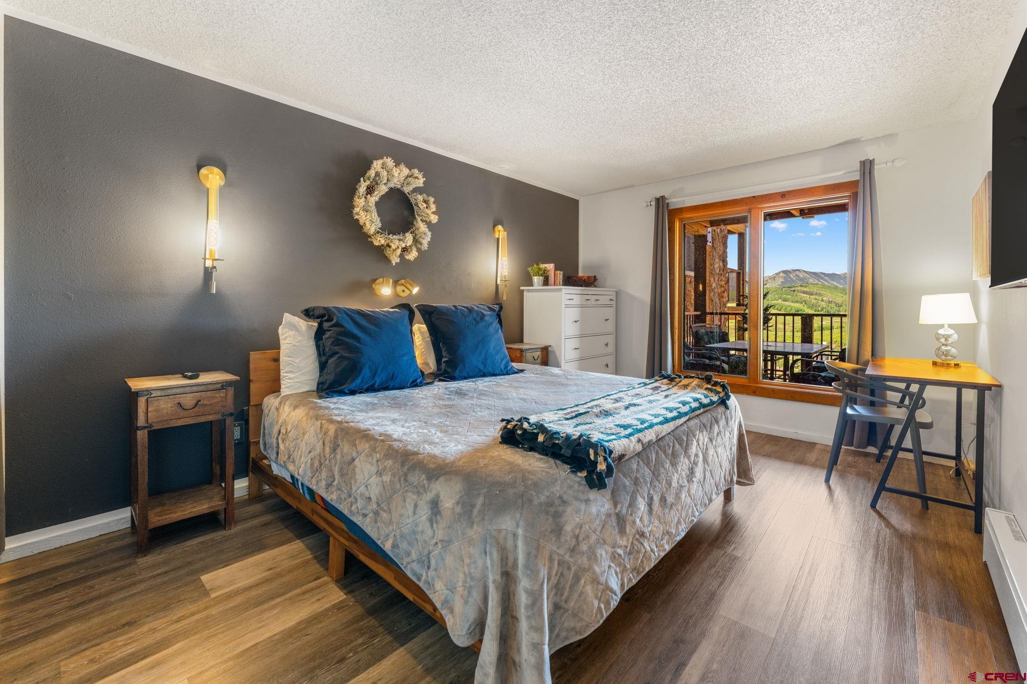 72 Hunter Hill Road, Unit I204 Crested Butte, CO 81225 - Photo 16 of 44 a bedroom with a bed and wooden floor