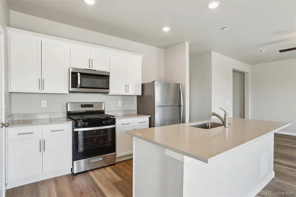 a kitchen with stainless steel appliances a stove a sink a microwave and cabinets