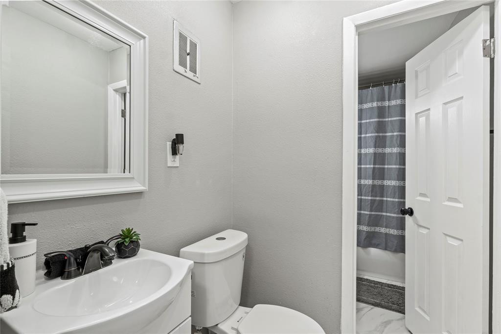 513 East Tyler Street Richardson, TX 75081 - Photo 14 of 18 a white toilet sitting next to a bathroom sink