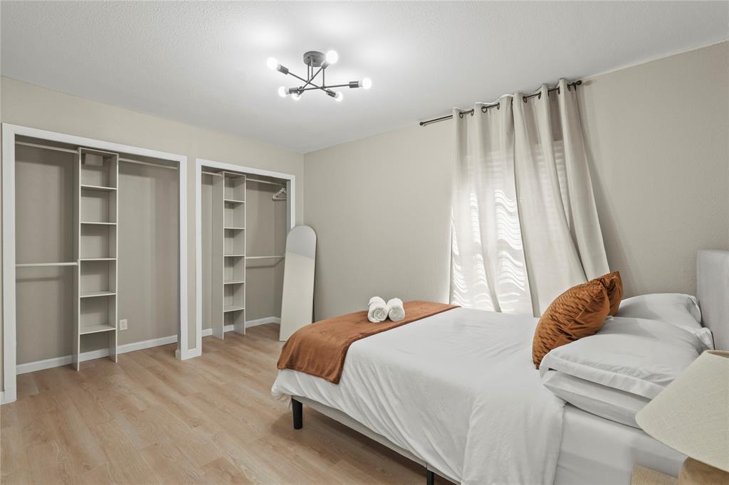 513 East Tyler Street Richardson, TX 75081 - Photo 15 of 18 a bedroom with a bed and a chandelier