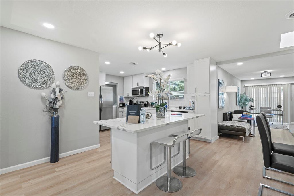 513 East Tyler Street Richardson, TX 75081 - Photo 7 of 18 a very nice looking room with kitchen island furniture and a wooden floor