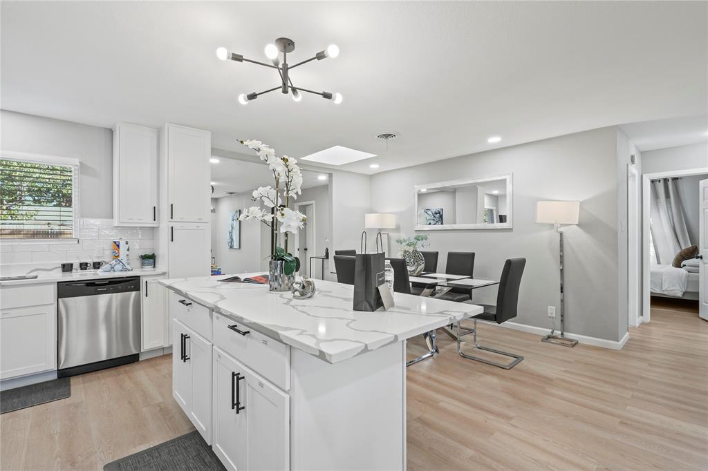513 East Tyler Street Richardson, TX 75081 - Photo 9 of 18 a open kitchen with stainless steel appliances kitchen island a stove a refrigerator a sink dishwasher and a fireplace with wooden floor