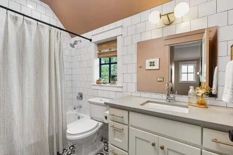 a bathroom with a granite countertop sink toilet and shower
