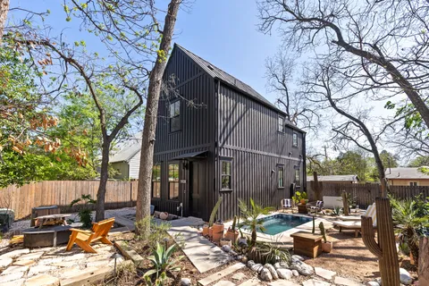 a view of backyard with outdoor seating and trees
