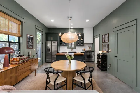 a kitchen with a dining table chairs stainless steel appliances and cabinets