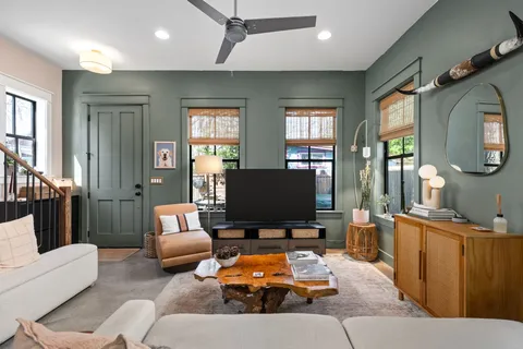 a living room with furniture a flat screen tv and a large window