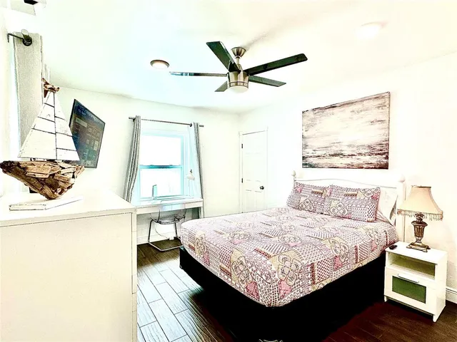 a bedroom with a bed and a flat tv screen on a dresser