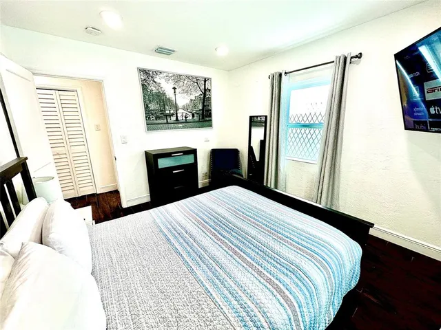 a bedroom with a bed and wooden floor