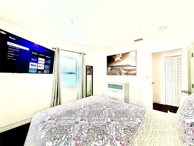 a bedroom with a bed and a flat screen tv