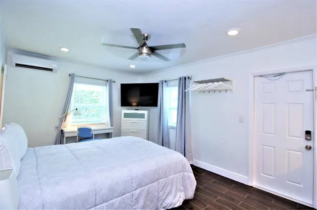 a bedroom with a large bed and a flat tv screen