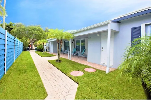 a view of a backyard with table and chairs under an umbrella