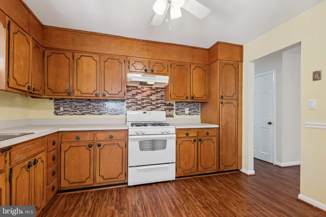 a kitchen with stainless steel appliances granite countertop a sink and cabinets with wooden floors