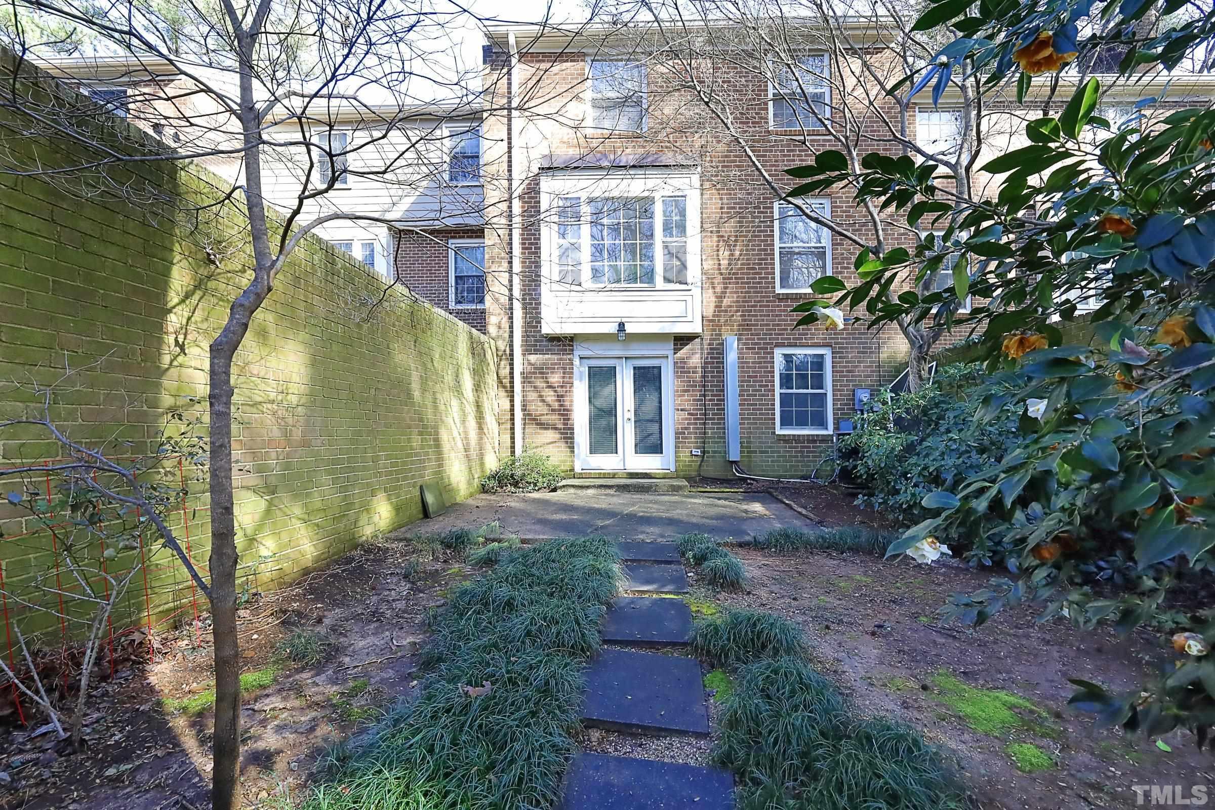 2838 Wycliff Road Raleigh, NC 27607 - Photo 31 of 39 a view of a big yard in front of a brick house with large windows