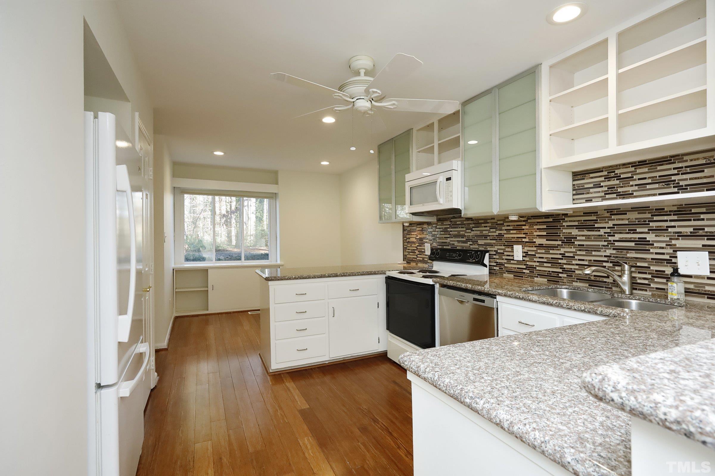 2838 Wycliff Road Raleigh, NC 27607 - Photo 8 of 39 a kitchen with a stove a sink and a refrigerator