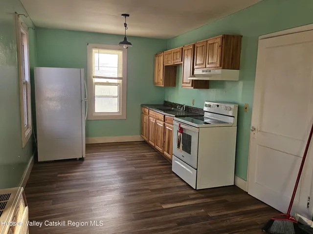 a kitchen with wooden floors and white cabinets