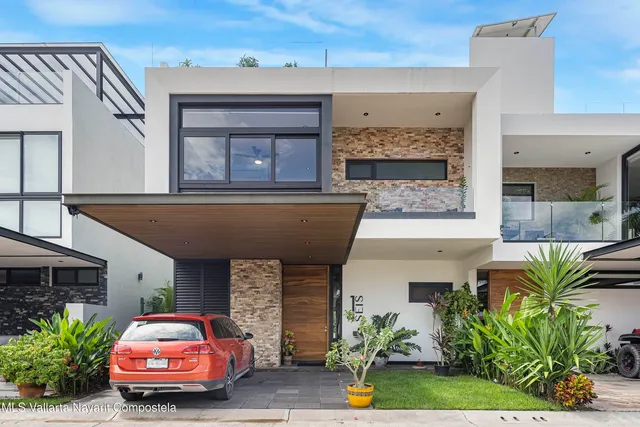 a front view of a house with plants